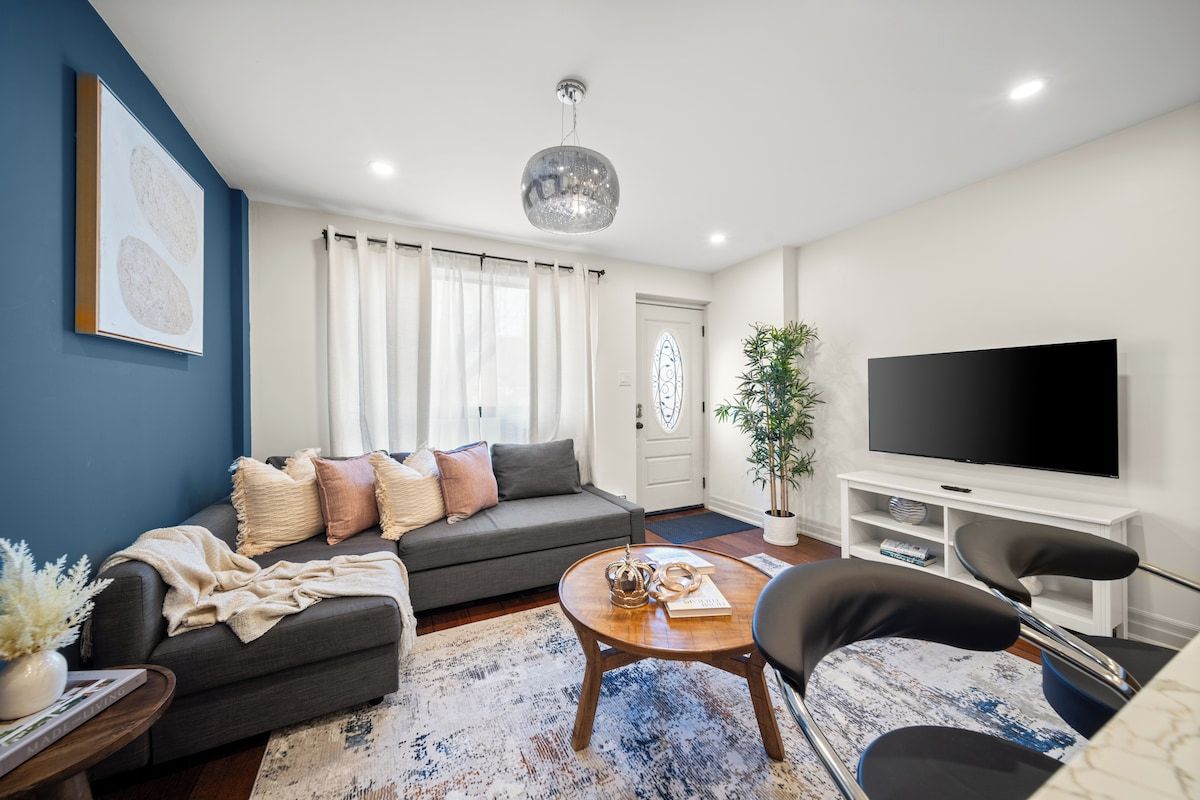 A modern living room with a sofa, coffee table, and a flat-screen TV.