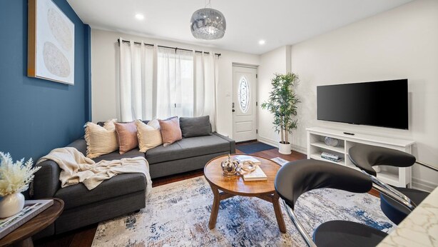 Una sala de estar moderna con un sofá, una mesa de centro y un televisor de pantalla plana.
