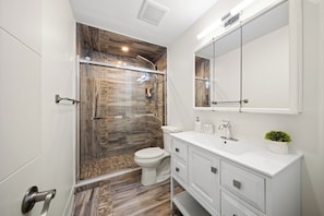 A modern bathroom with a shower, toilet, and vanity. - Modern Queen West Escape Sleeps 6 with Parking (Toronto)