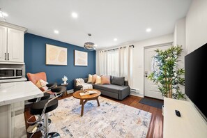 A modern living room with a sofa, coffee table, and a TV. - Modern Queen West Escape Sleeps 6 with Parking (Toronto)