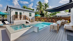 A pool area with a wooden deck, lounge chairs, and a small building with a balcony. - **SUNSET ON FOGARTY @ MIDTOWN** Newly Renovated Home & Pool + Last Key White Glo (Key West)