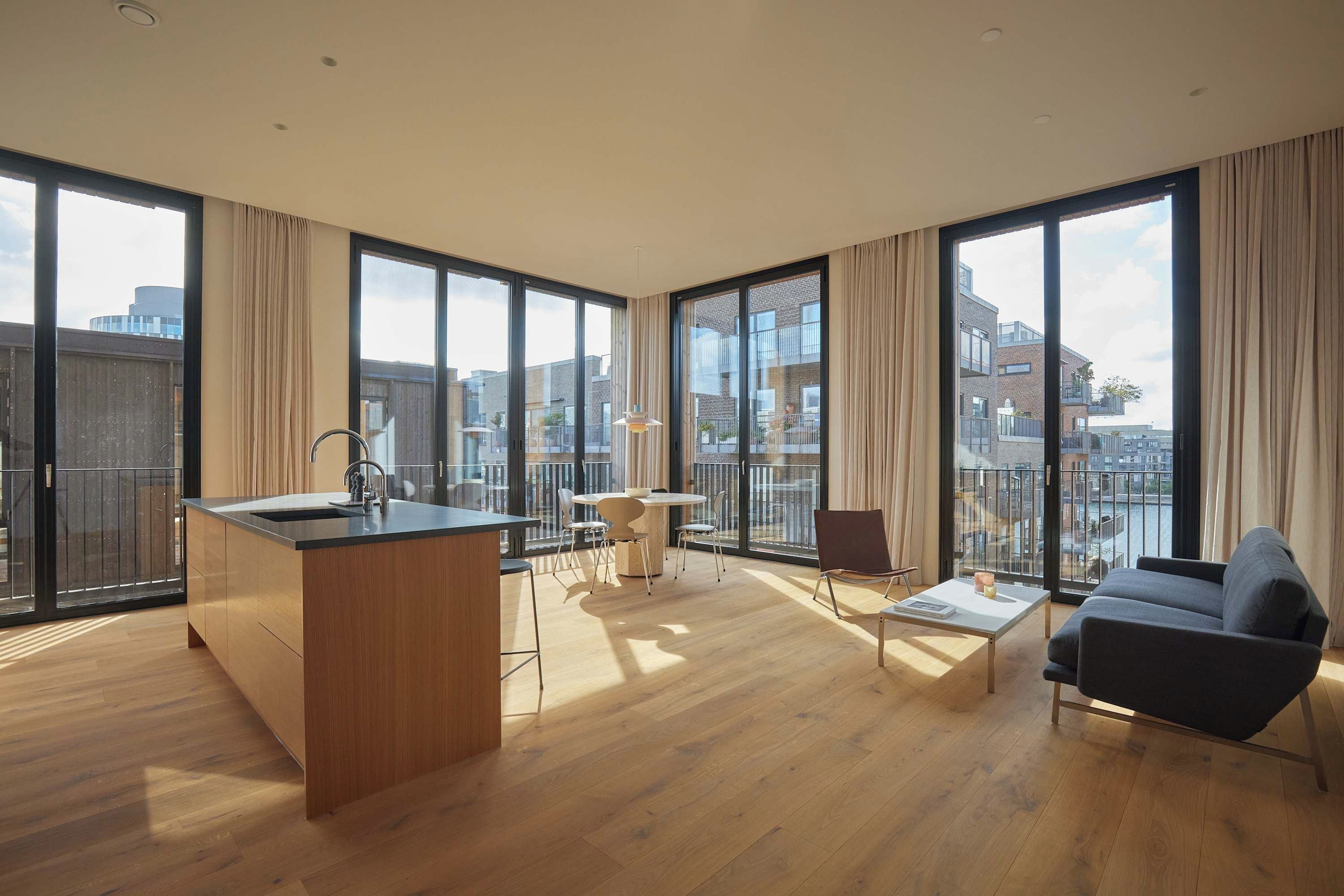 Un apartamento moderno con una isla de cocina, zona de comedor y sofá.