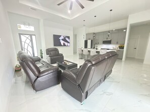 A modern living room with a sectional sofa, a coffee table, and a flat-screen TV.