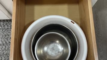 Uma tigela de metal branca dentro de uma gaveta de madeira.
