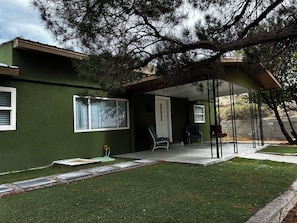 Ein Haus mit Veranda, Rasen und Fenster.