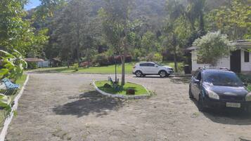 Un camino de entrada pavimentado que conduce a un edificio con coches estacionados.