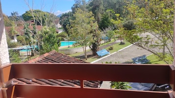 A residential area with a swimming pool, trees, and a clear sky.