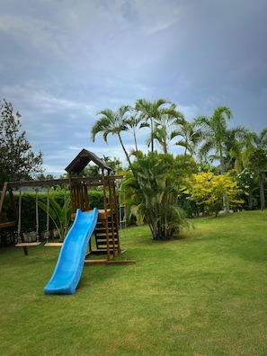 A playground with a slide and swings. - Private 3-Bed Villa · Huge 860m² Garden · Mountain View · Gated · Long Stays (Tambon Nong Kae)
