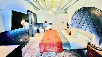 Een slaapkamer met een bed, bureau, kledingkast en spiegel.