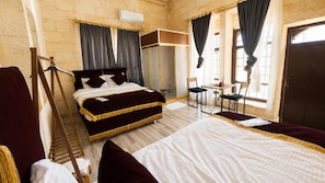 Una habitación con una cama grande, un armario, un escritorio y una silla.