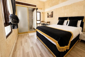 Un dormitorio con una cama grande, suelo de madera, una puerta corredera y un cuadro en la pared.