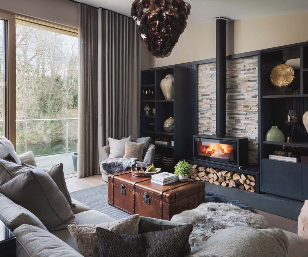 A cozy living room with a fireplace, a sofa, a coffee table, and a bookshelf.