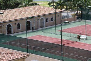 A tennis court with a building in the background. - LUXURY WATERFRONT PENTHOUSE PRIVATE POOL 3 BEDROOM 3 BATHROOM (Lowlands)