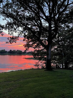 A large tree in the foreground with a lake and a sunset in the background. - Eastern Shore Waterfront Retreat. Easy Access to Easton and St Michaels. (Denton)