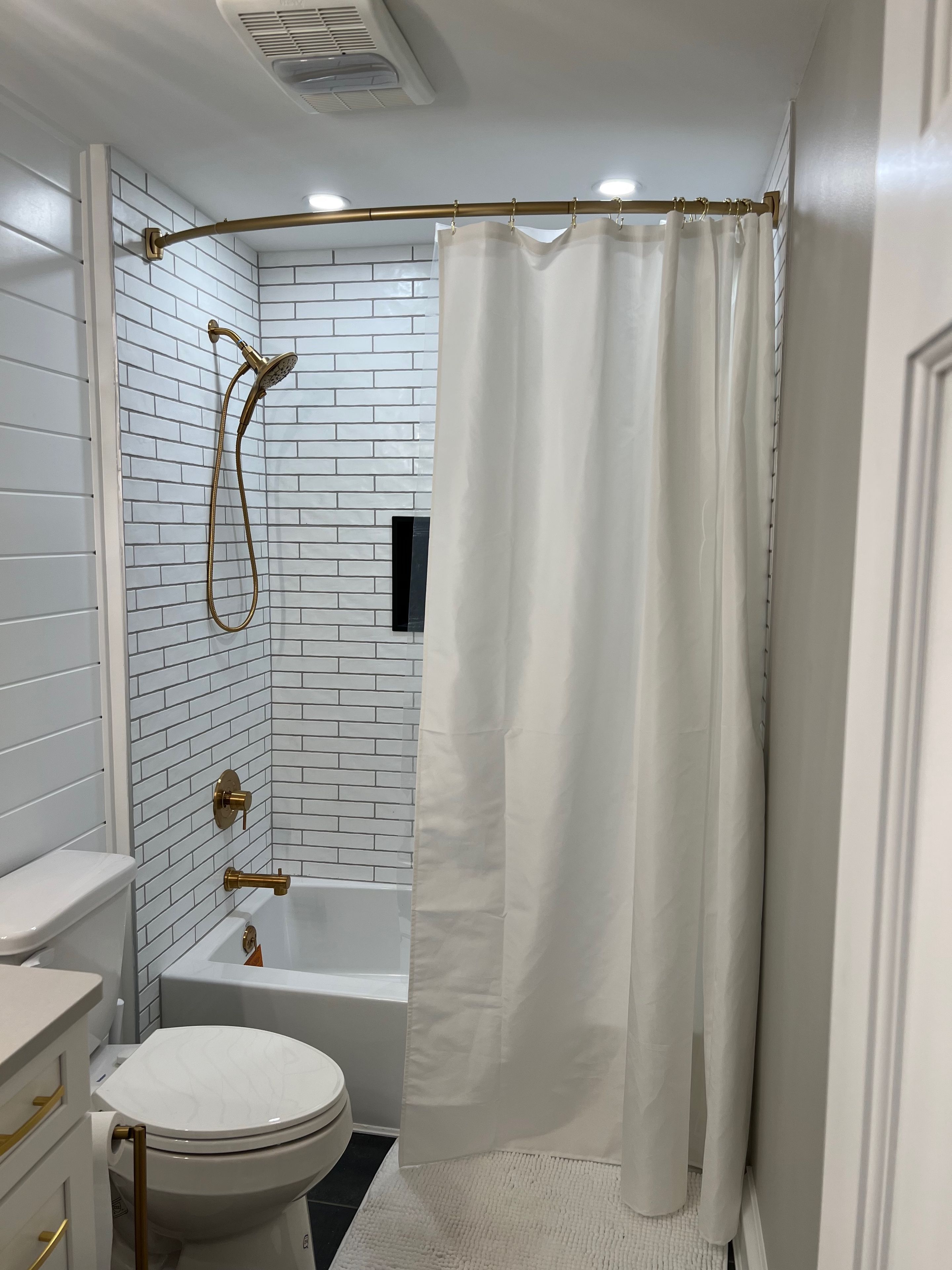 A bathroom with a white toilet, a bathtub, and a shower with a curtain.