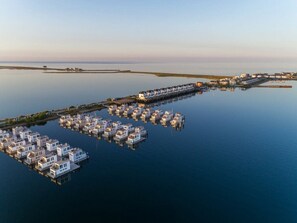 An aerial view of a waterfront property with multiple floating houses connected by a dock. - Holiday Home in Kappeln With Swimming Pool (Kappeln)