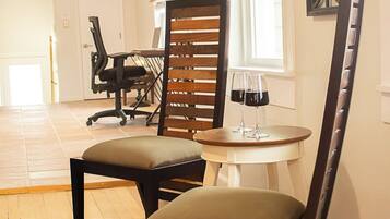 A dining area with two chairs, a table, and a window with blinds.