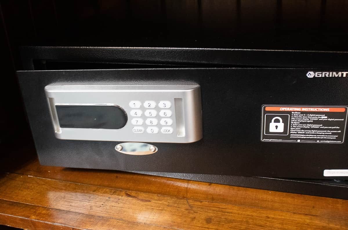 A secure electronic keypad lock on a black surface, possibly a safe or vault, with a label indicating operating instructions.