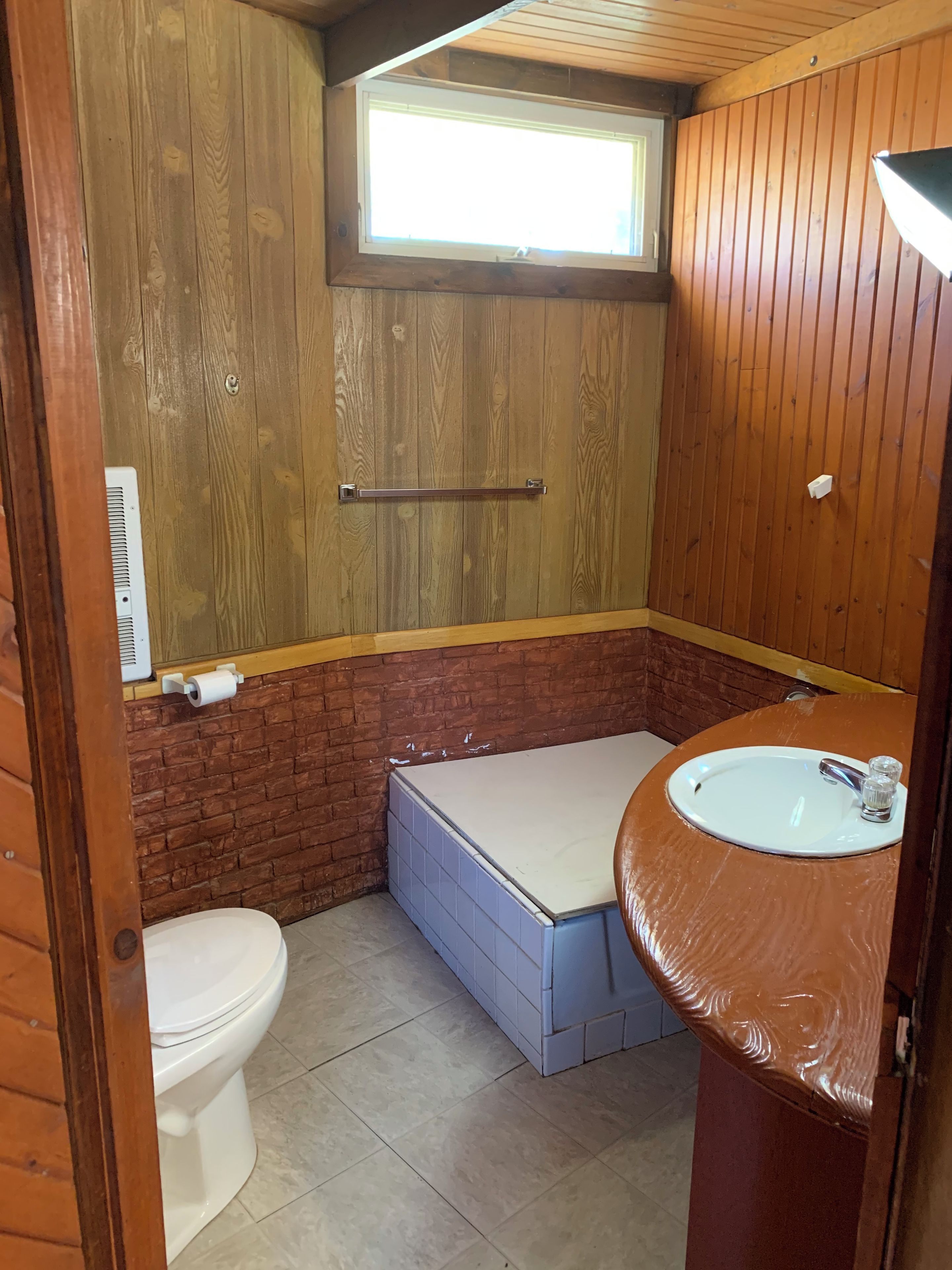 Ein kleines Badezimmer mit Toilette, Waschbecken und Badewanne.