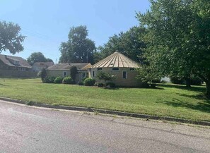 A residential area with houses, a grassy lawn, and a road. - Cozy 2-bedroom converted grain bin, check listing for bedroom details (Covington)