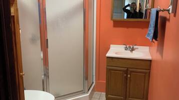 A bathroom with a toilet, a shower enclosure, and a sink.
