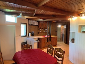 A compact kitchen with a refrigerator, a coffee maker, and a microwave. There is a dining area with a table and chairs. - Cozy 2-bedroom converted grain bin, check listing for bedroom details (Covington)