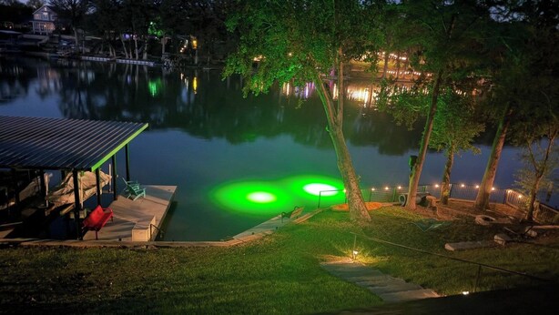 Zona junto al lago con un muelle, un área de descanso techada y una orilla de césped bien cuidada.