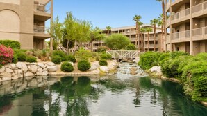 Un hotel con varios pisos, un patio central con fuente y palmeras.