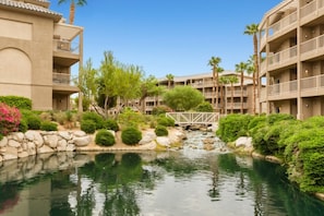 A hotel with multiple floors, a central courtyard with a water feature, and palm trees. - WM BLOCK Indio Studio (Indio)