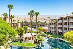 A hotel with multiple floors, a swimming pool, and palm trees. - WM BLOCK Indio Studio (Indio)