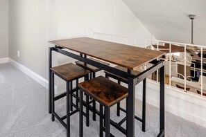 Ein kleiner Essbereich mit einem Holztisch und zwei passenden Hocker.