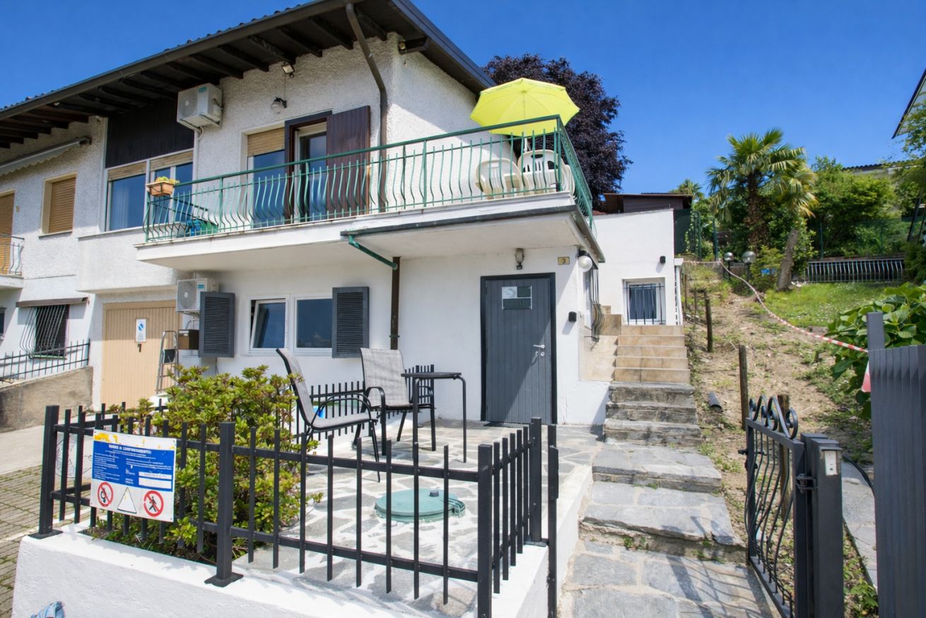 A two-story building with a balcony, outdoor seating, and a sign indicating no parking.