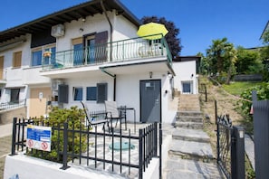 A two-story building with a balcony, outdoor seating, and a sign indicating no parking.