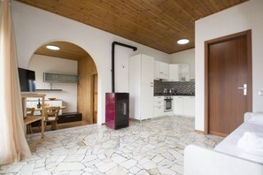 A modern kitchen with white cabinets, a black stove, and a tiled backsplash.