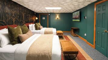 Habitación de hotel con dos camas, un banco, un televisor y una decoración de pared.