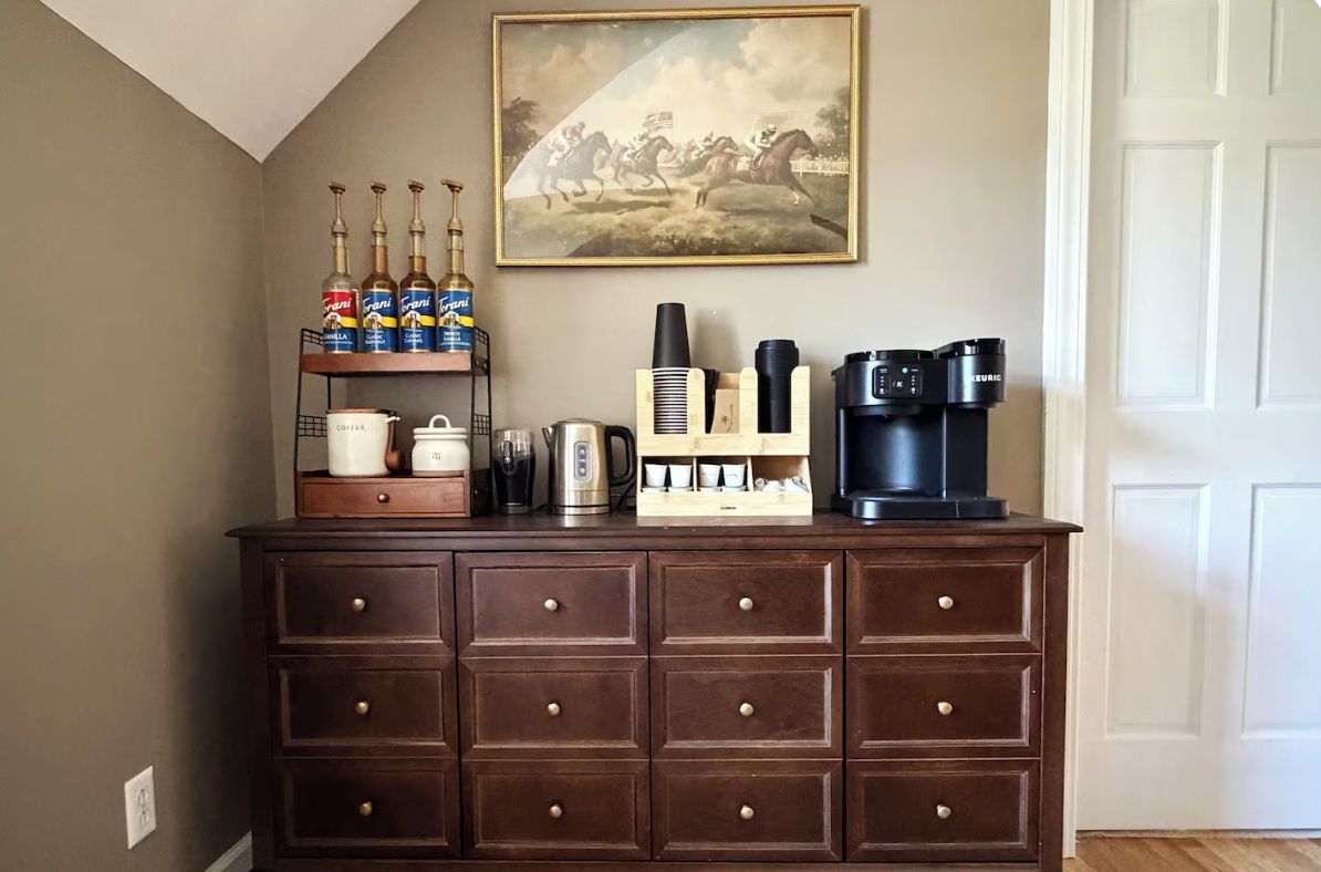 Eine Küchenarbeitsplatte mit Kaffeemaschine, Kaffeemühle und einer Ablage mit Flaschen.