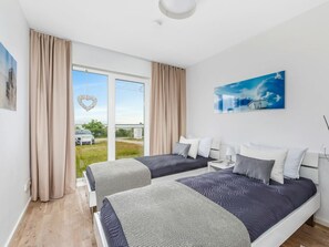 A hotel room with two beds, a large window, and a painting on the wall. - Holiday Apartment With 2 Bedrooms (Kappeln)