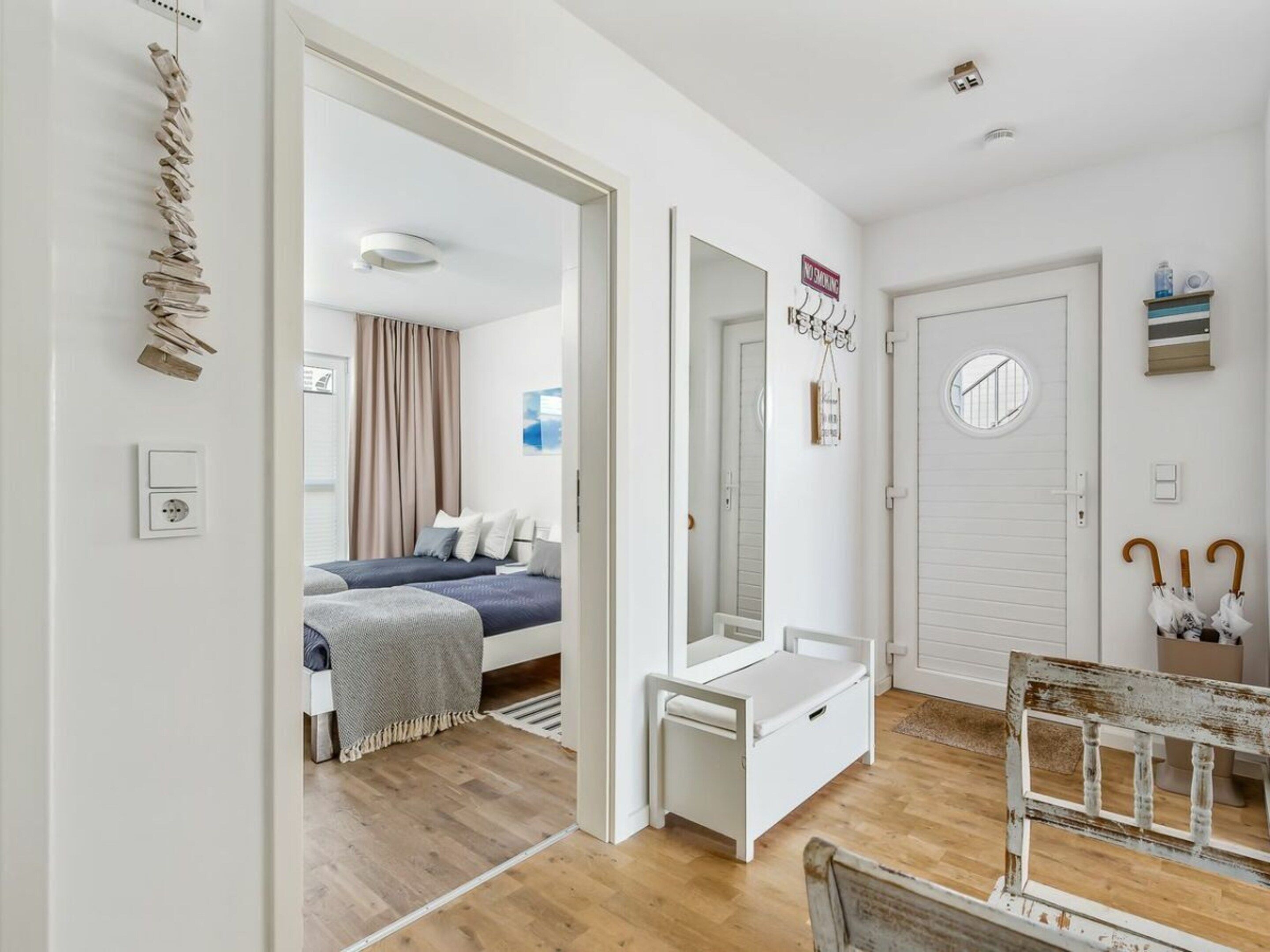 Ein Zimmer mit einem Bett, einem Schreibtisch, einem Spiegel und einer Tür.