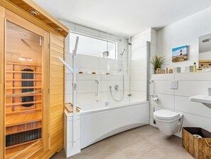 A modern bathroom with a glass-enclosed shower, a wooden sauna, and a white sink. - Holiday Apartment With 2 Bedrooms (Kappeln)