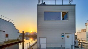A modern building with a flat roof, a large window, and a small door. - Houseboat in Olpenitz With Swimming Pool (Kappeln)