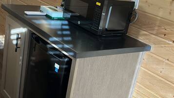 A compact kitchen with a built-in dishwasher, a microwave, and a sink.