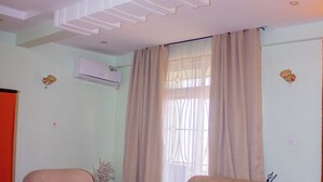 A living room with two sofas, a coffee table, and a small plant. - Kibui Hotel Ilazo (Dodoma)