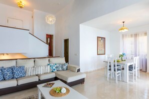 Ein modernes Wohnzimmer mit einer Couch, einem Couchtisch und einem Essbereich.