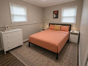 A bedroom with a bed, nightstands, a dresser, and a rug. - Perfect Saratoga Location: beautiful 4-bedroom house near downtown & SPA Park (Saratoga Springs)