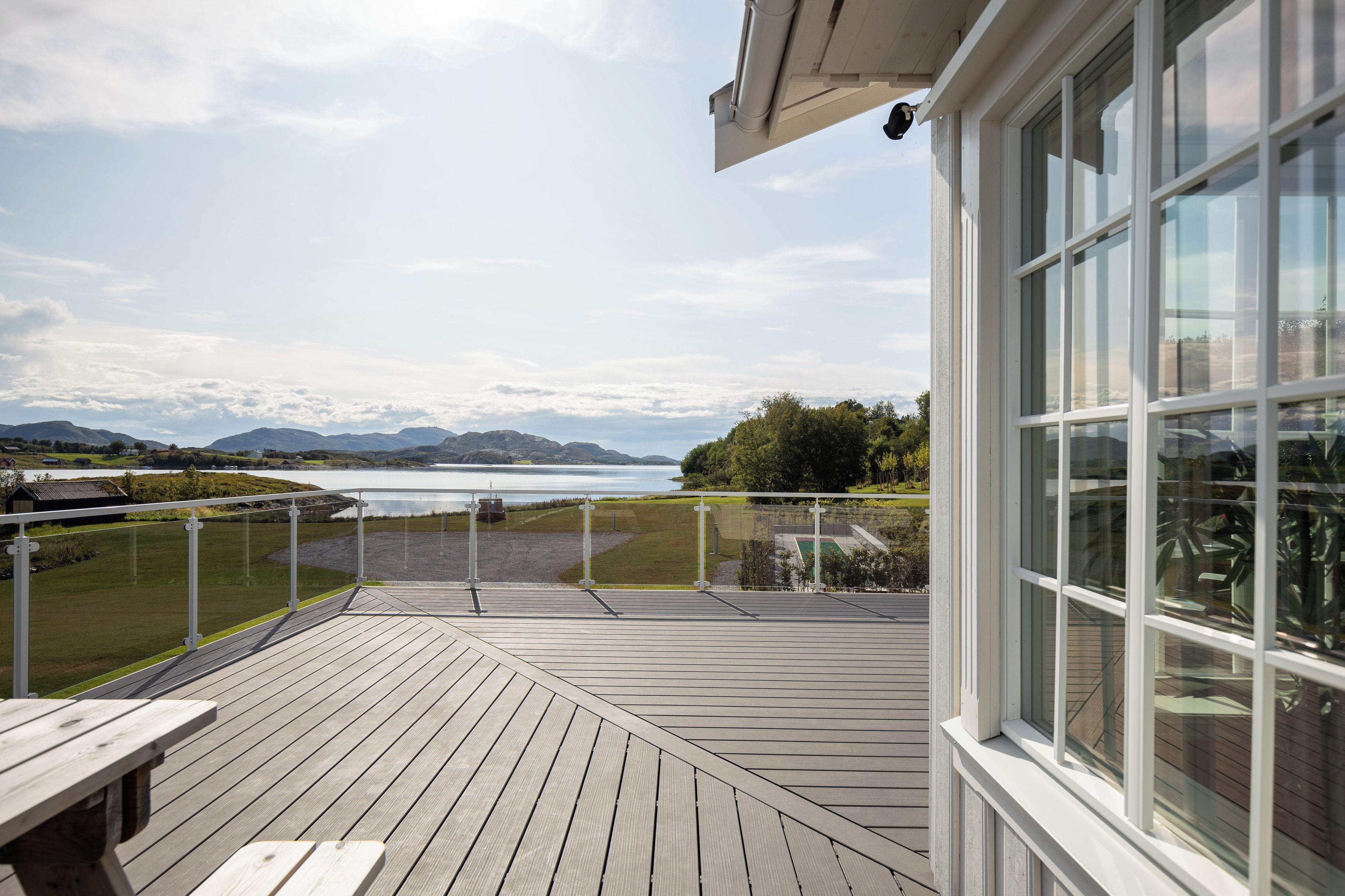 A wooden deck with a view of a lake and mountains.