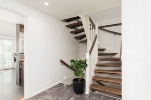 A staircase with wooden steps and white railings, leading to an upper floor.
