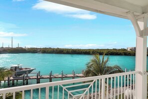 A waterfront property with a dock, a boat, and a view of the sea and greenery. - Luxury Waterfront 5BD/4Bth private pool 36' dock (Marathon)