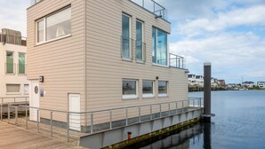 A modern building with a flat roof, large windows, and a balcony. - Houseboat in Kappeln With Swimming Pool (Kappeln)