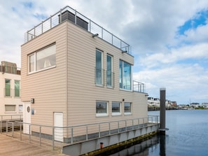Un edificio moderno con techo plano, ventanas amplias y un balcón.
