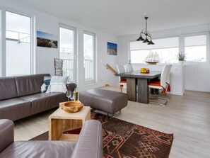 Una sala de estar moderna con un sofá gris, una mesa de centro de madera y una alfombra estampada.